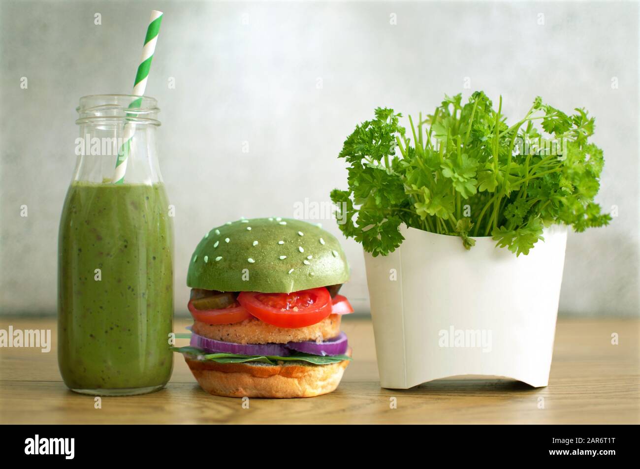 Des aliments sains et rapides, du hamburger vert, du smoothie aux légumes et de la salade dans un récipient à frites Banque D'Images