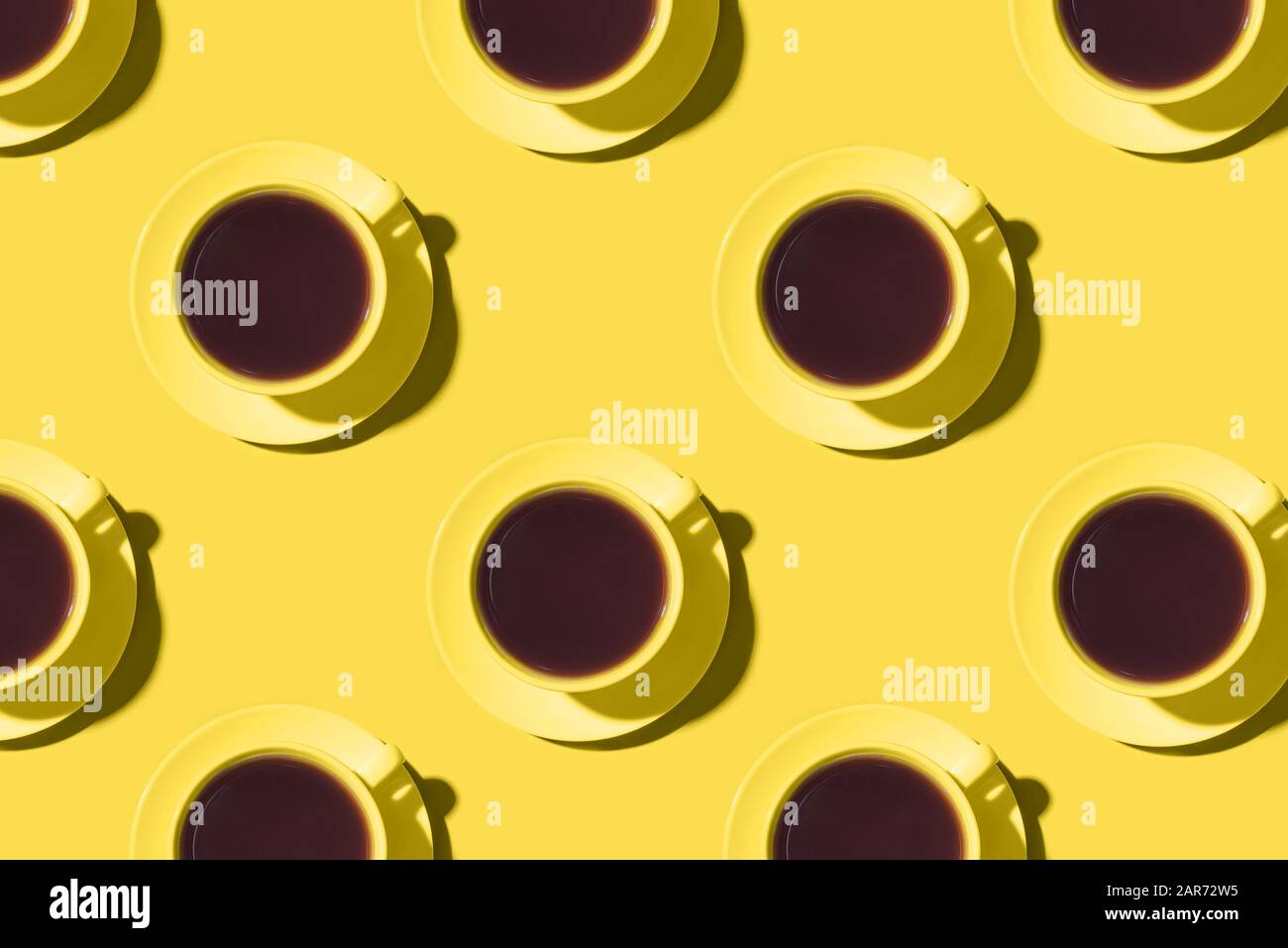 Motif de tasses de café ou de thé noir sur fond jaune. Banque D'Images