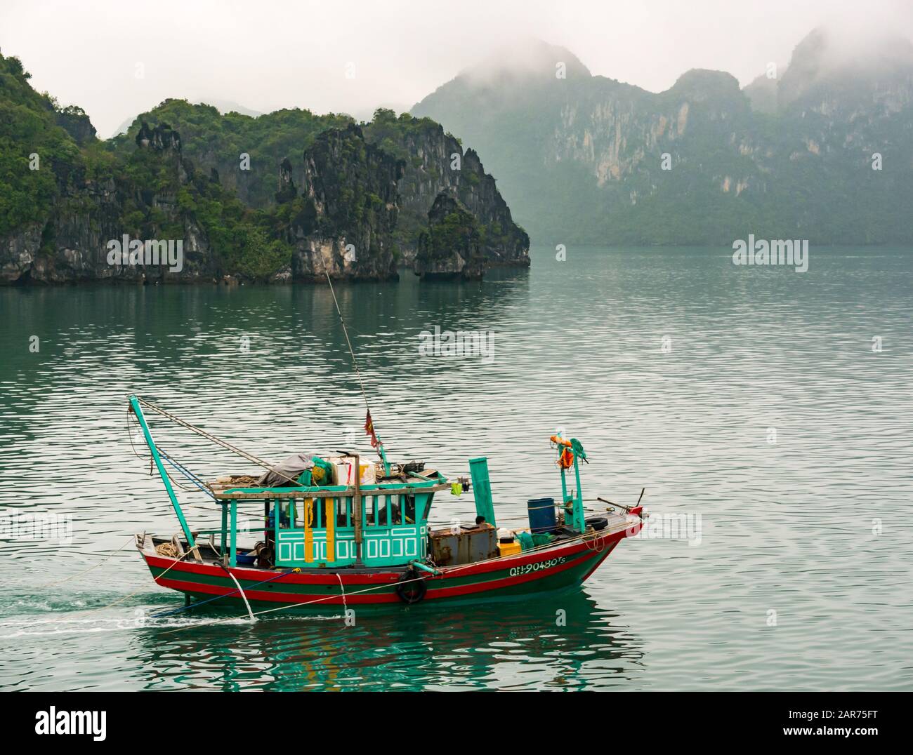 Bateau de pêche vietnamien avec falaises de karst de roche calcaire, Baie Lan Ha, Vietnam, Asie Banque D'Images