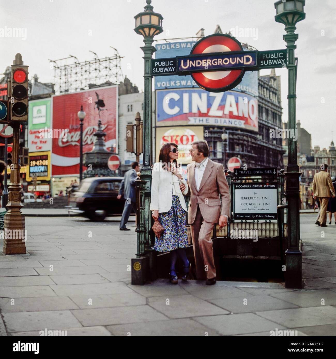 Londres 1970s, couple élégant, sortie de métro public, panneau de métro Evening, Piccadilly Circus, Angleterre, Royaume-Uni,GB, Grande-Bretagne, Banque D'Images