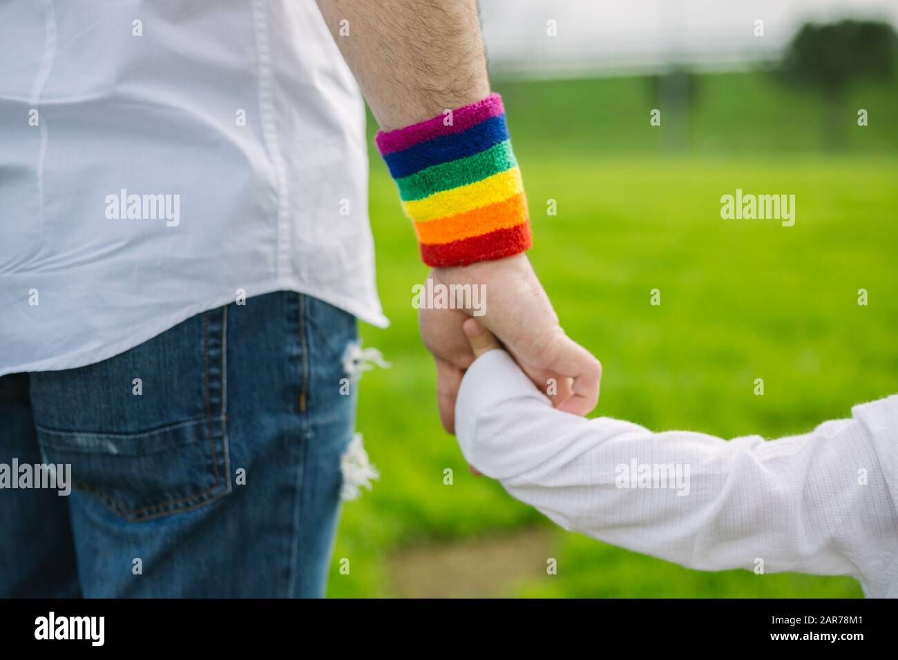 Père avec fierté gay drapeau arc-en-ciel bracelet et son fils marchant dans le parc. Concept paternel Banque D'Images