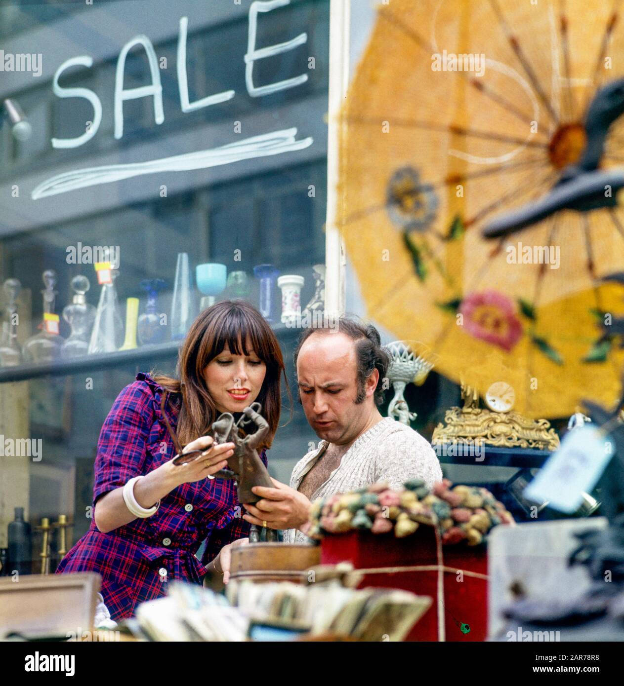 Londres 1970, femme shopping et marchand d'antiquités, rue à l'extérieur de magasin d'exposition, Kensington, Angleterre, Royaume-Uni, GB, Grande-Bretagne, Banque D'Images