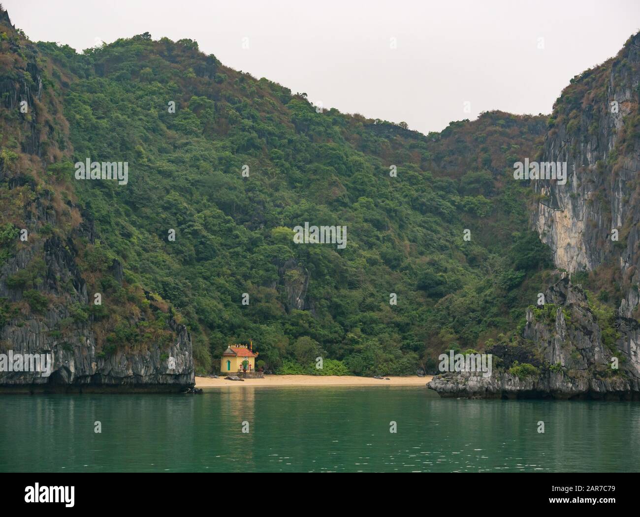 Temple bouddhiste solitaire sur la plage dans la baie de sable avec falaises de roche calcaire, Lan Ha Bay, Vietnam, Asie Banque D'Images