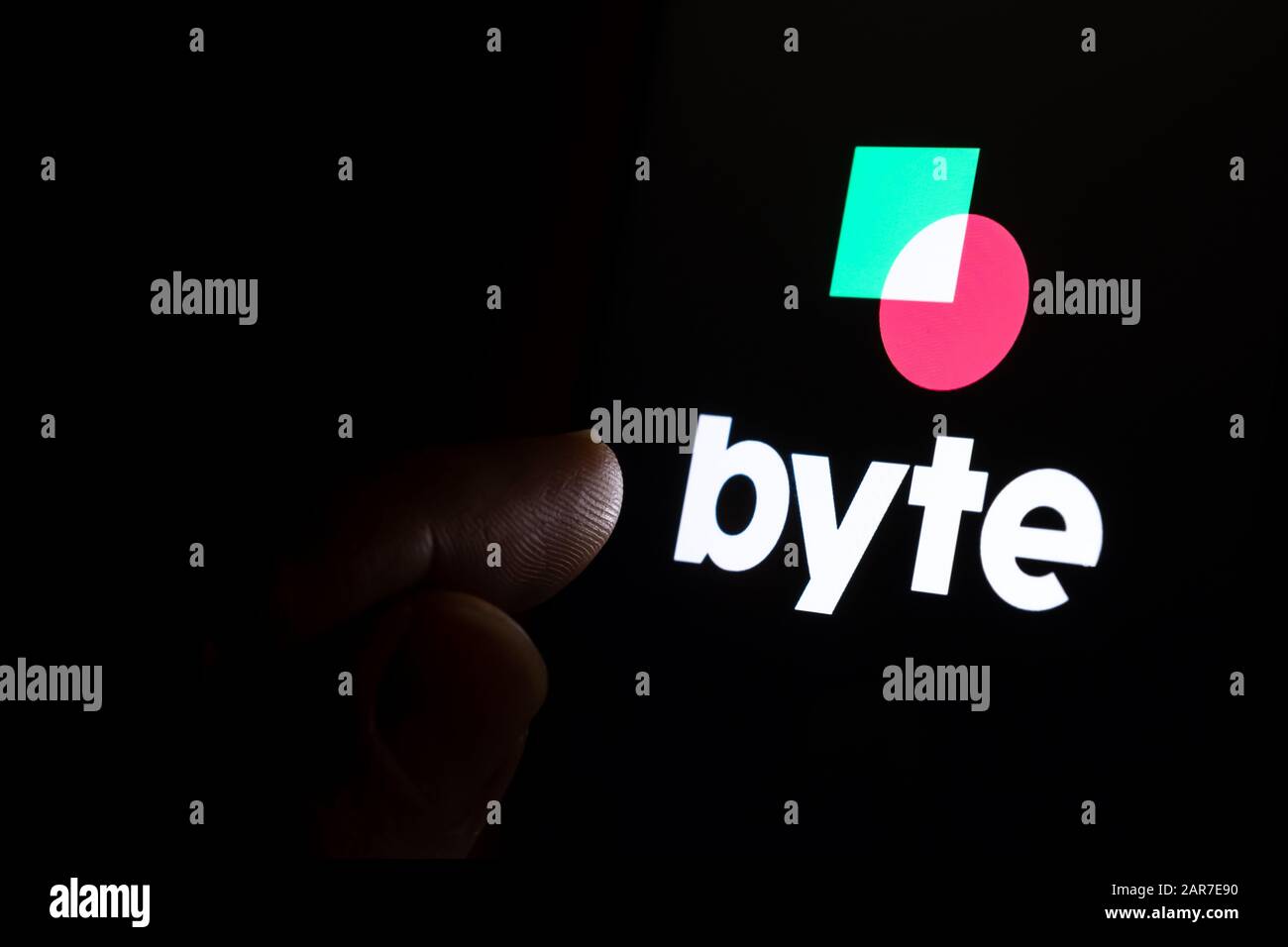 Le logo de l'application BYTE sur l'écran tactile sombre et le doigt lui pointent. BYTE New social media Platform concurrent de TikTok. Banque D'Images