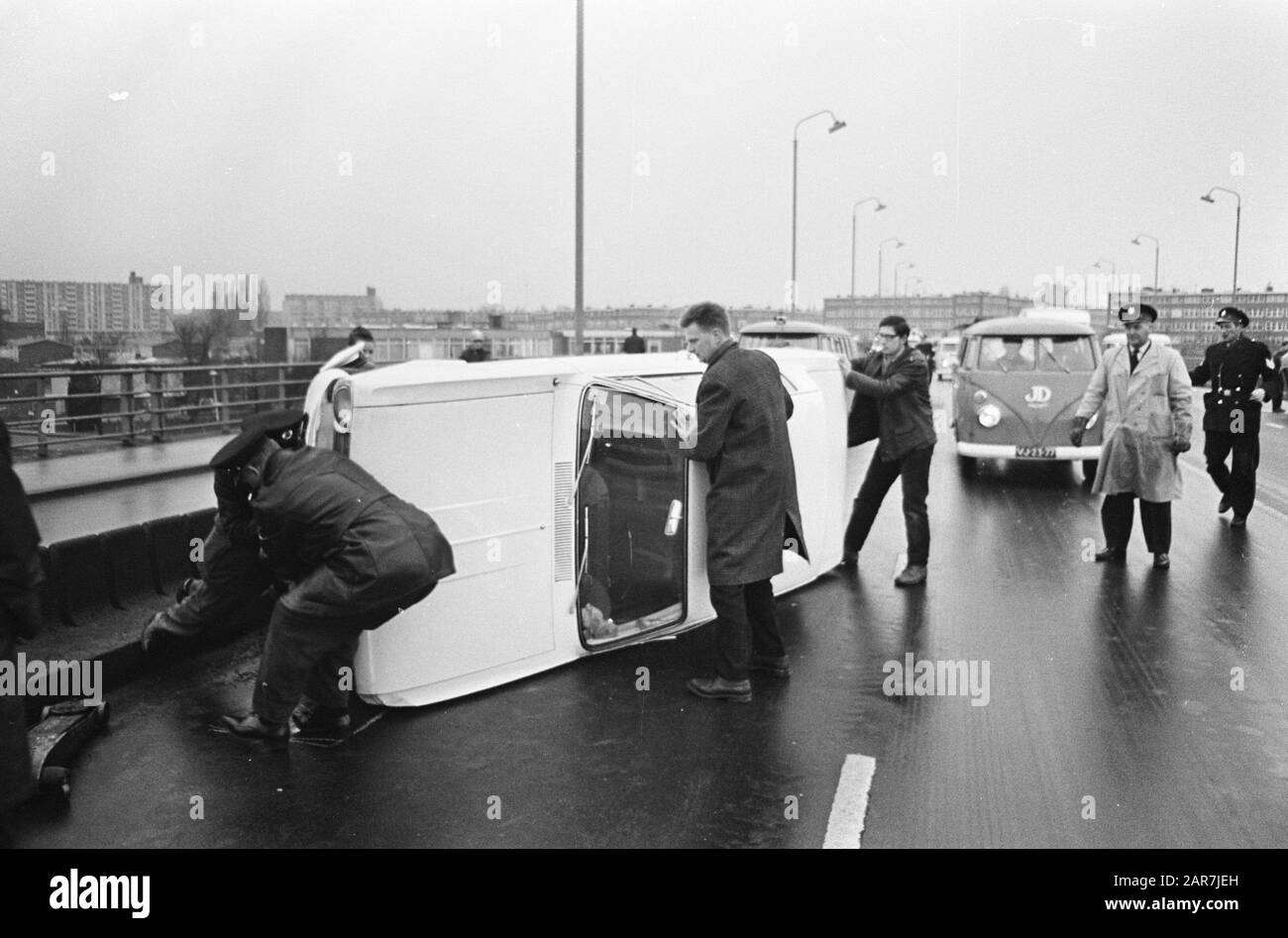 La camionnette de passagers se trouve de son côté sur le parc d'attractions d'Utrecht près du président Kennedylaan, une voiture de tourisme inclinée est aidée à ses pieds Date: 23 janvier 1967 mots clés: Voitures de tourisme Banque D'Images