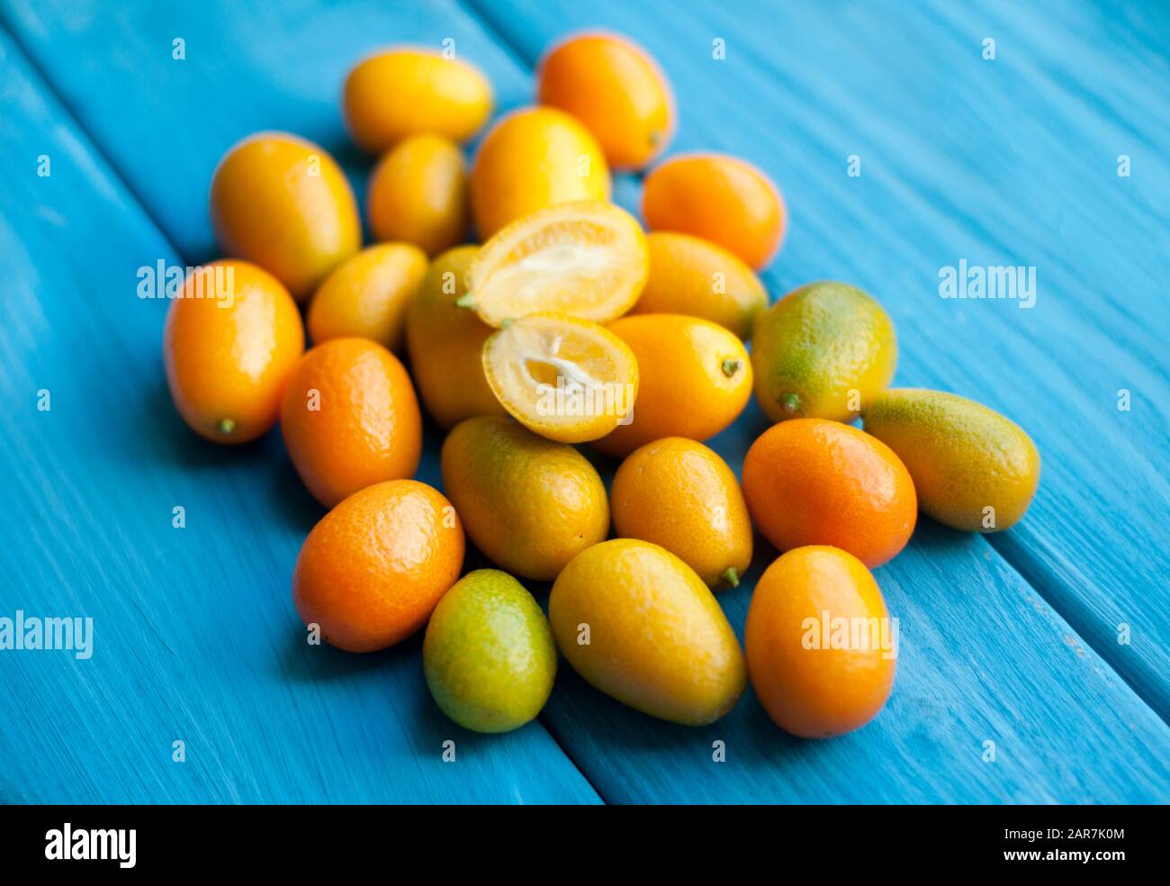 Kumquat sur fond bleu. Agrumes orange brillant Banque D'Images