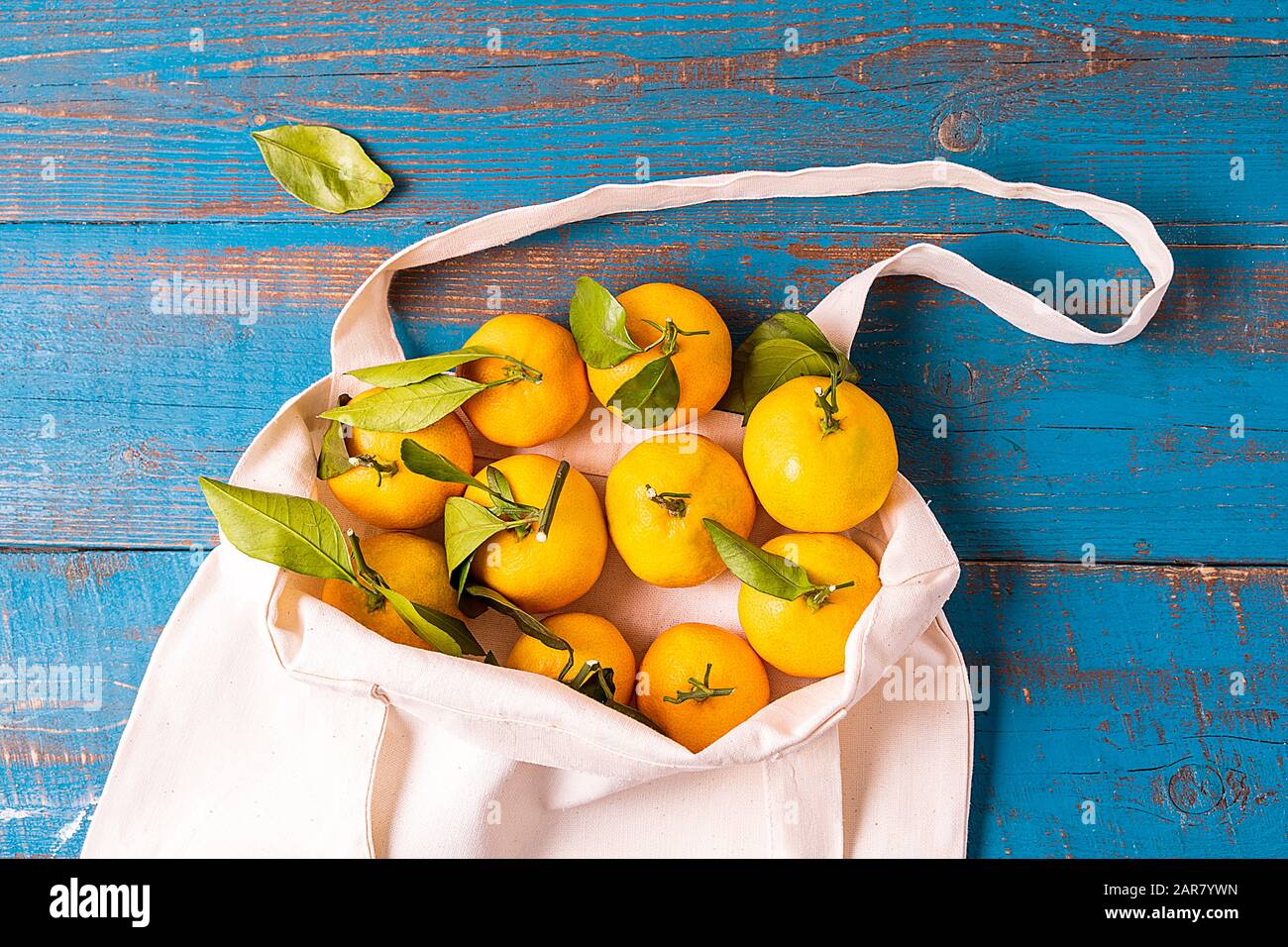 Plat posez Des mandarines Fraîches dans le sac à provisions en textile éco réutilisable zéro déchet sur fond blanc, orientation horizontale. Banque D'Images