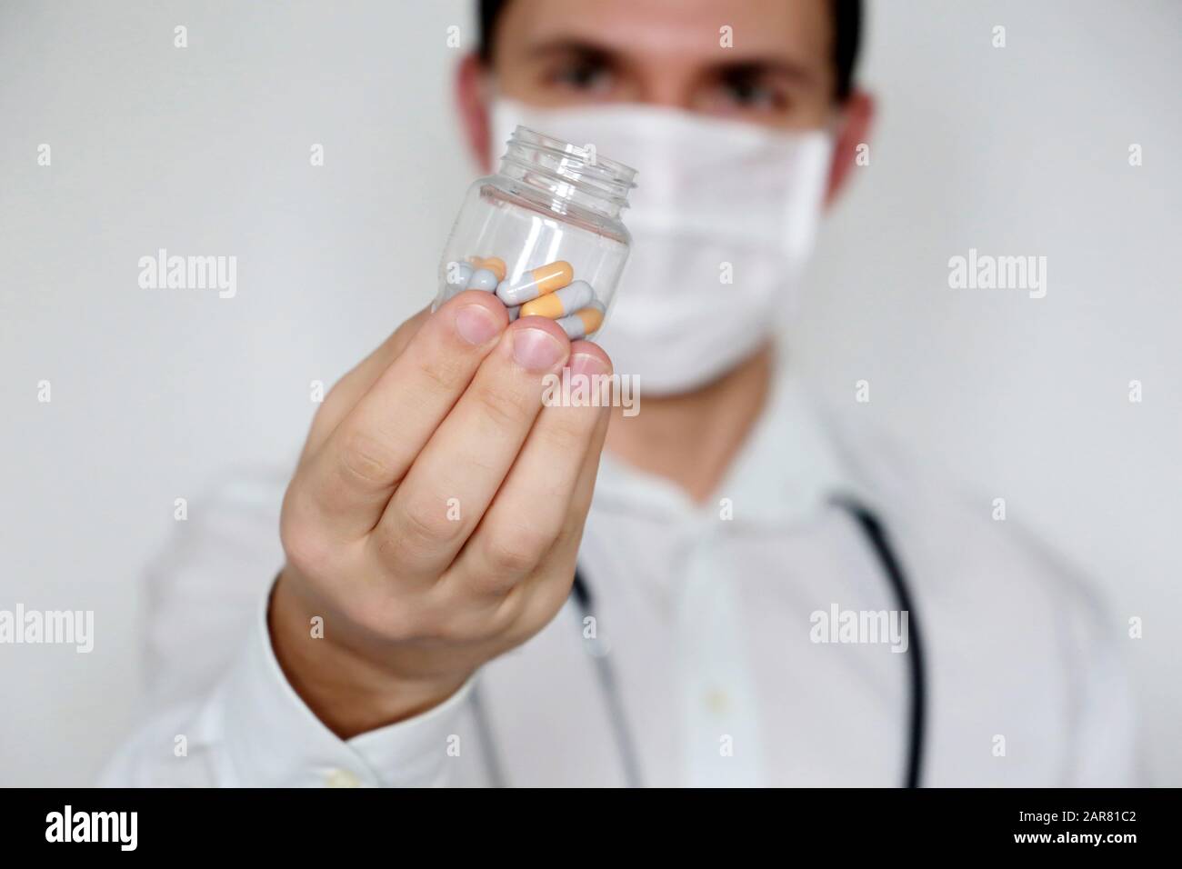 Médecin donnant des pilules, médecin dans le masque médical avec flacon de capsules. Concept de dose de médicaments, vitamines, examen médical, coronavirus, traitement de la grippe Banque D'Images