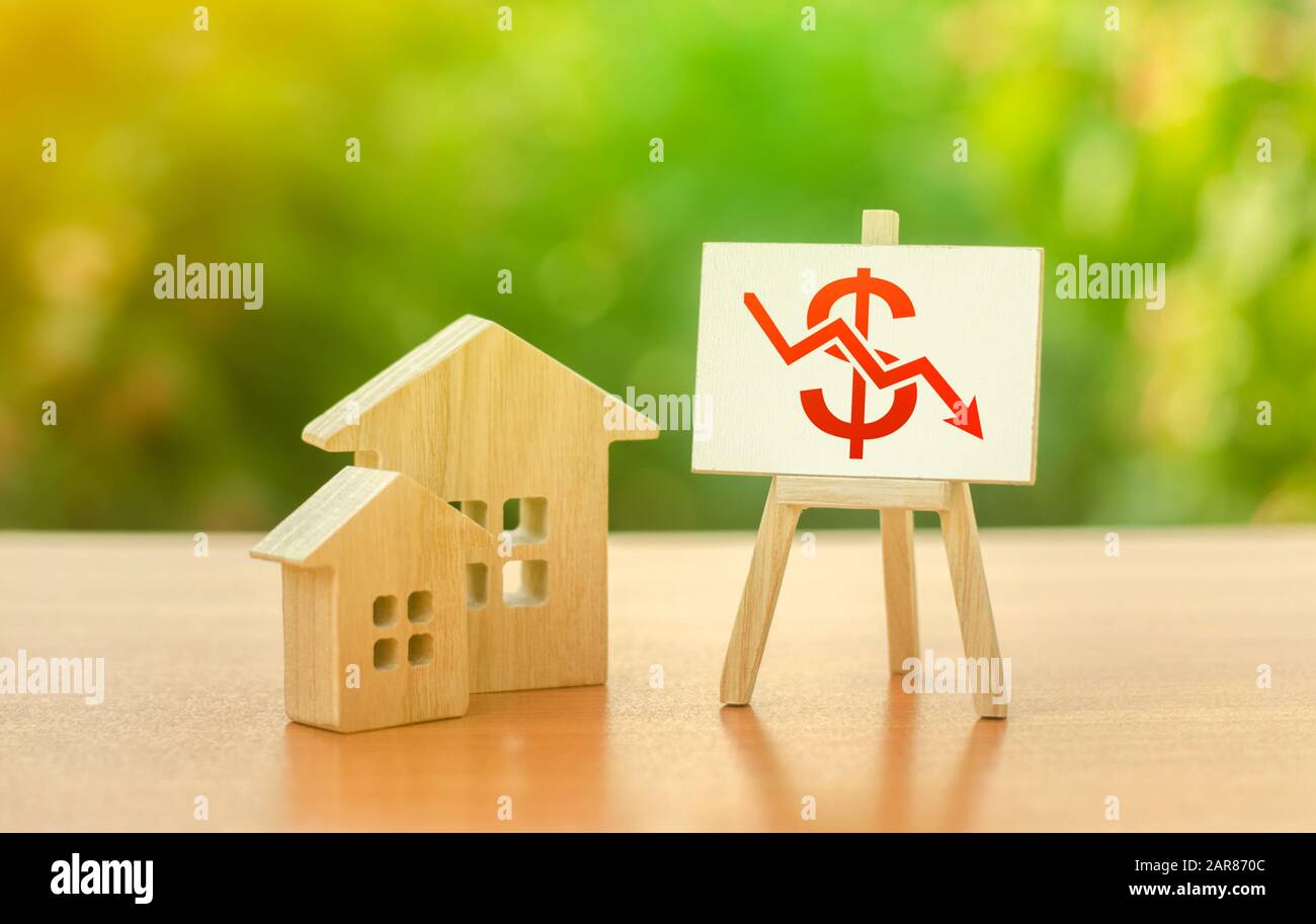 Maisons en bois et un tableau de tendance négatif de dollar rouge chevalet vers le bas. Réduction de la demande et de la stagnation. Faible attrait des investissements en liquidité. Chute réelle Banque D'Images
