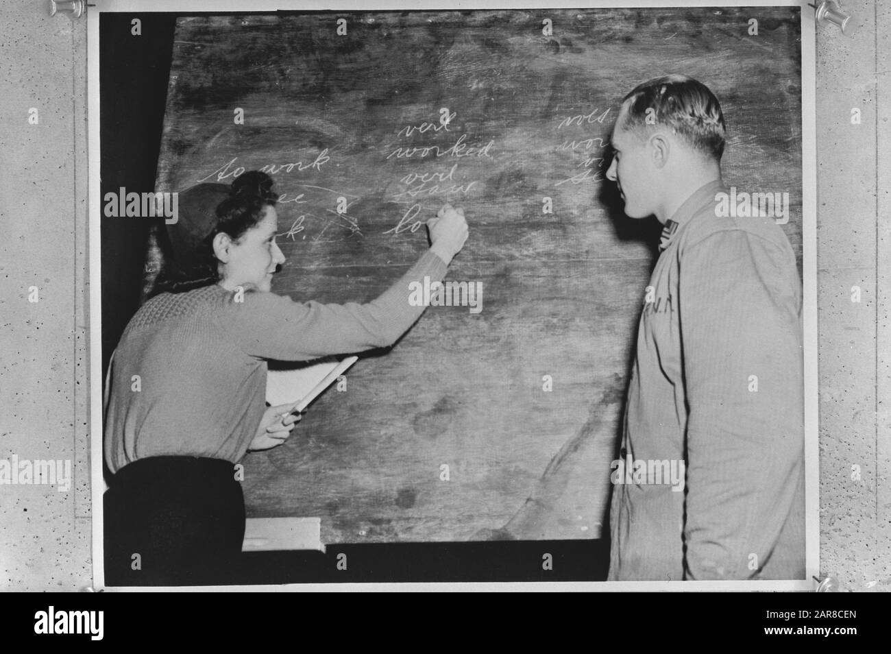Série De Formation À Camp Lejeune Pour Les Marines Néerlandaises. Deux heures de cours d'anglais par jour font partie de la formation de base. L'enseignant (épouse d'un officier néerlandais) écrit sur les conjugaisons de tableaux noirs des verbes anglais Annotation: Repronegative Date: 14 mai 1944 lieu: Camp Lejeune, Caroline du Nord, États-Unis d'Amérique mots clés: Marines, éducation, langues, formation, seconde guerre mondiale Banque D'Images