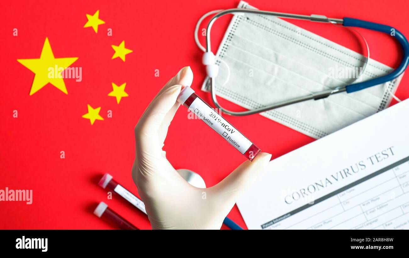 Tube de test avec main d'infirmière et sang pour test de coronavirus sur pavillon de Chine avec masque de protection respiratoire, stéthoscope, forme médicale, autre test- Banque D'Images