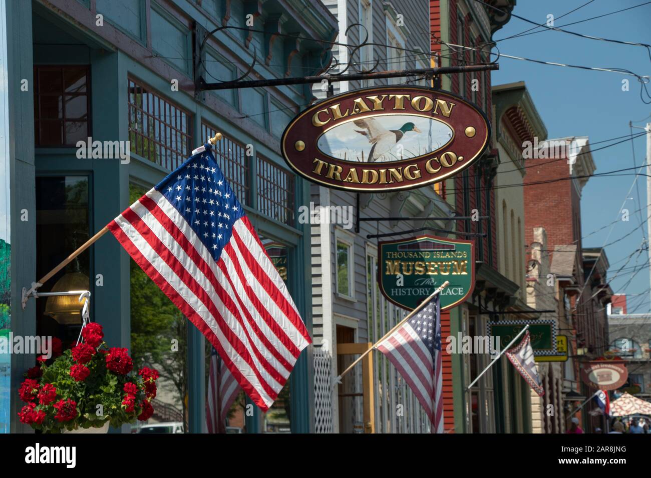 Clayton, NY, États-Unis - juillet 2019 : façade du Building Shop sur James St pendant la saison estivale, drapeaux américains et enseignes de magasins en bois de fer Banque D'Images