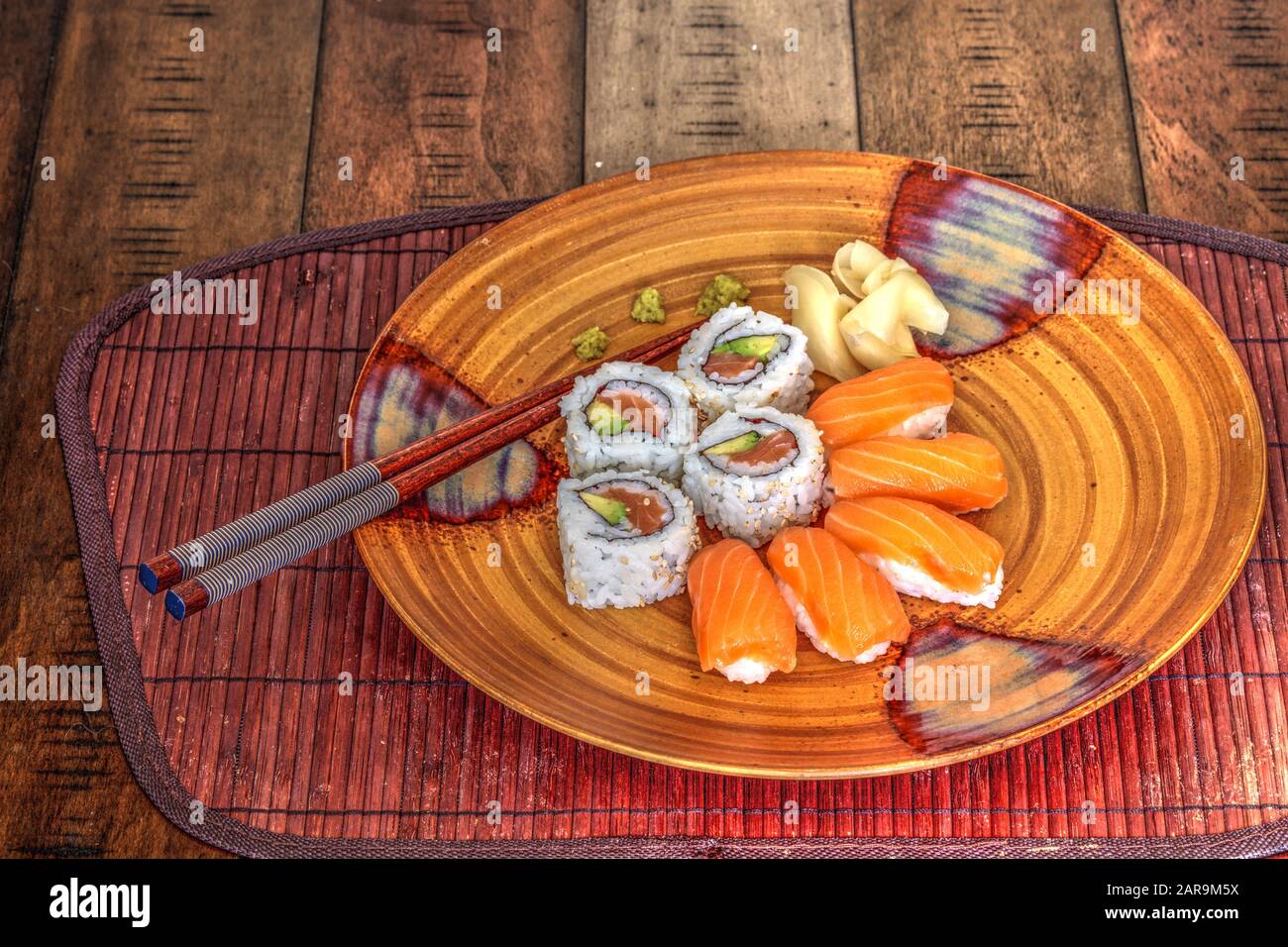 Petits pains à sushi au saumon et saké au wasabi, au gingembre et aux baguettes Banque D'Images