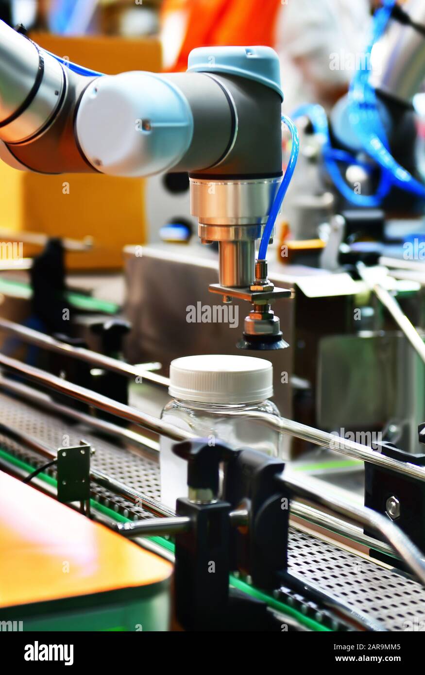 Le bras robot de verre disposés sur la bouteille d'eau dans l'équipement automatique de machines industrielles factory de la ligne de production Banque D'Images