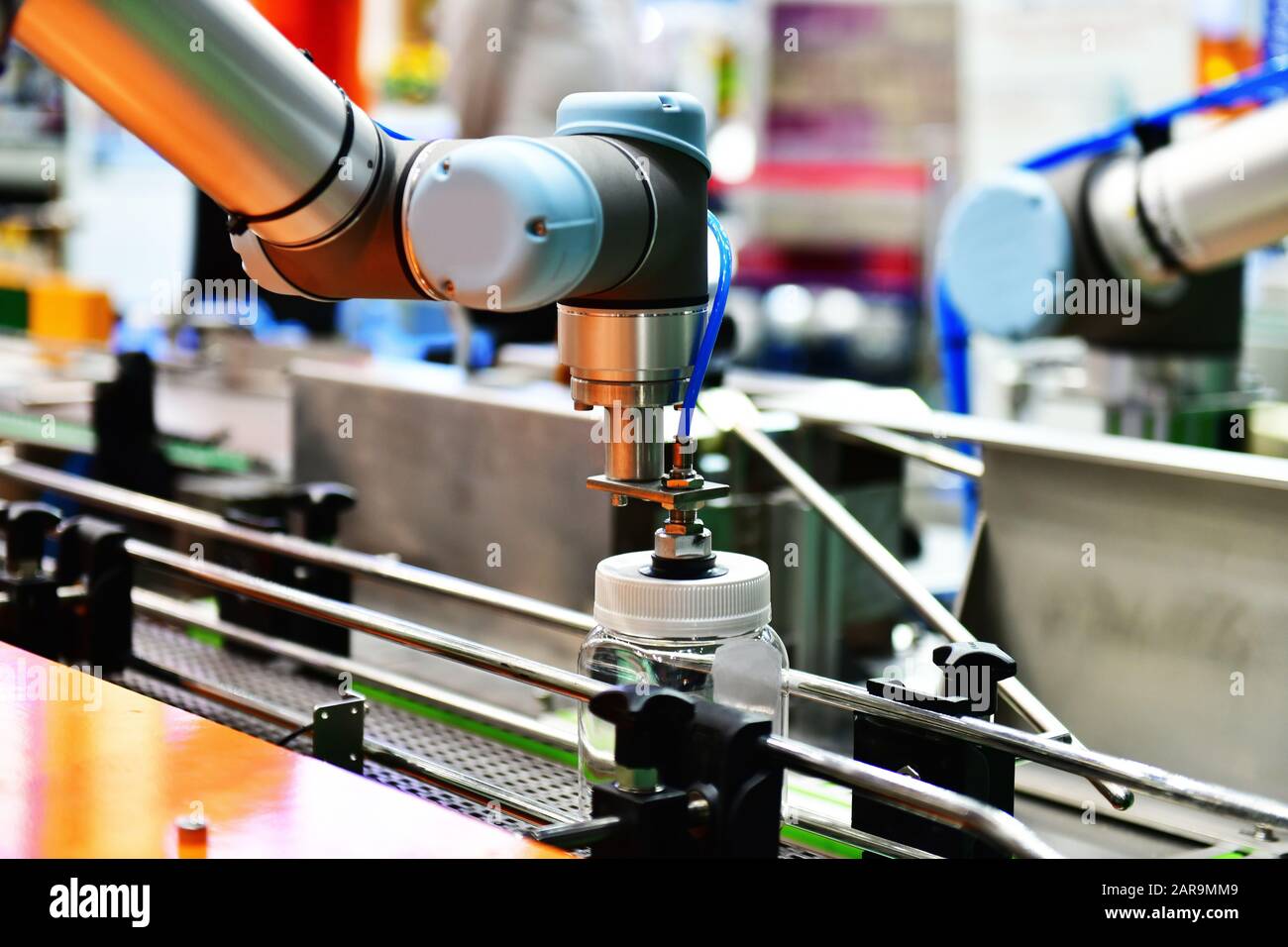 Le bras robot de verre disposés sur la bouteille d'eau dans l'équipement automatique de machines industrielles factory de la ligne de production Banque D'Images