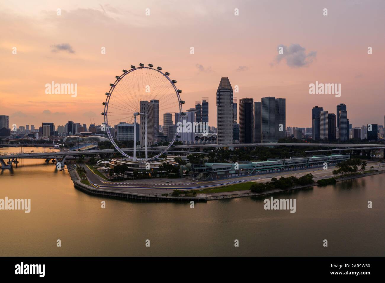 Coucher de soleil sur le front de mer de Singapour, près de Marina Bay, avec la célèbre roue Ferris à Singapour, en Asie du Sud-est Banque D'Images