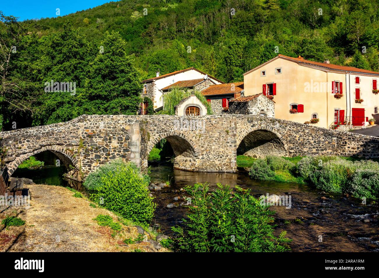 Pont en pierre sur le Pavin couze qui traverse le village de Saurier, Puy de Dome. Auvergne Rhône Alpes, France Banque D'Images