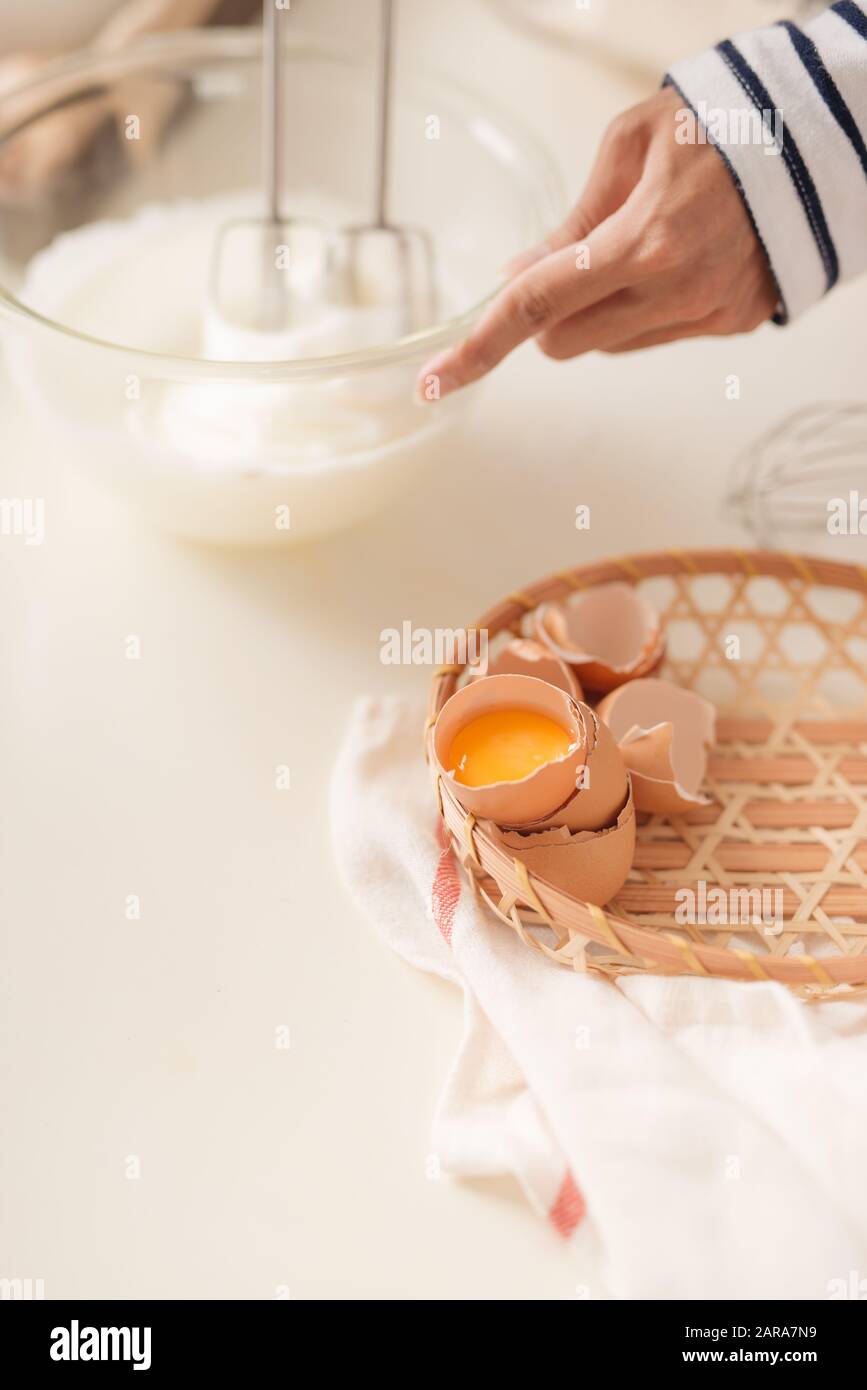 Le mélange crème oeufs blancs dans le bol mélangeur à pâte, le moteur avec cake Banque D'Images