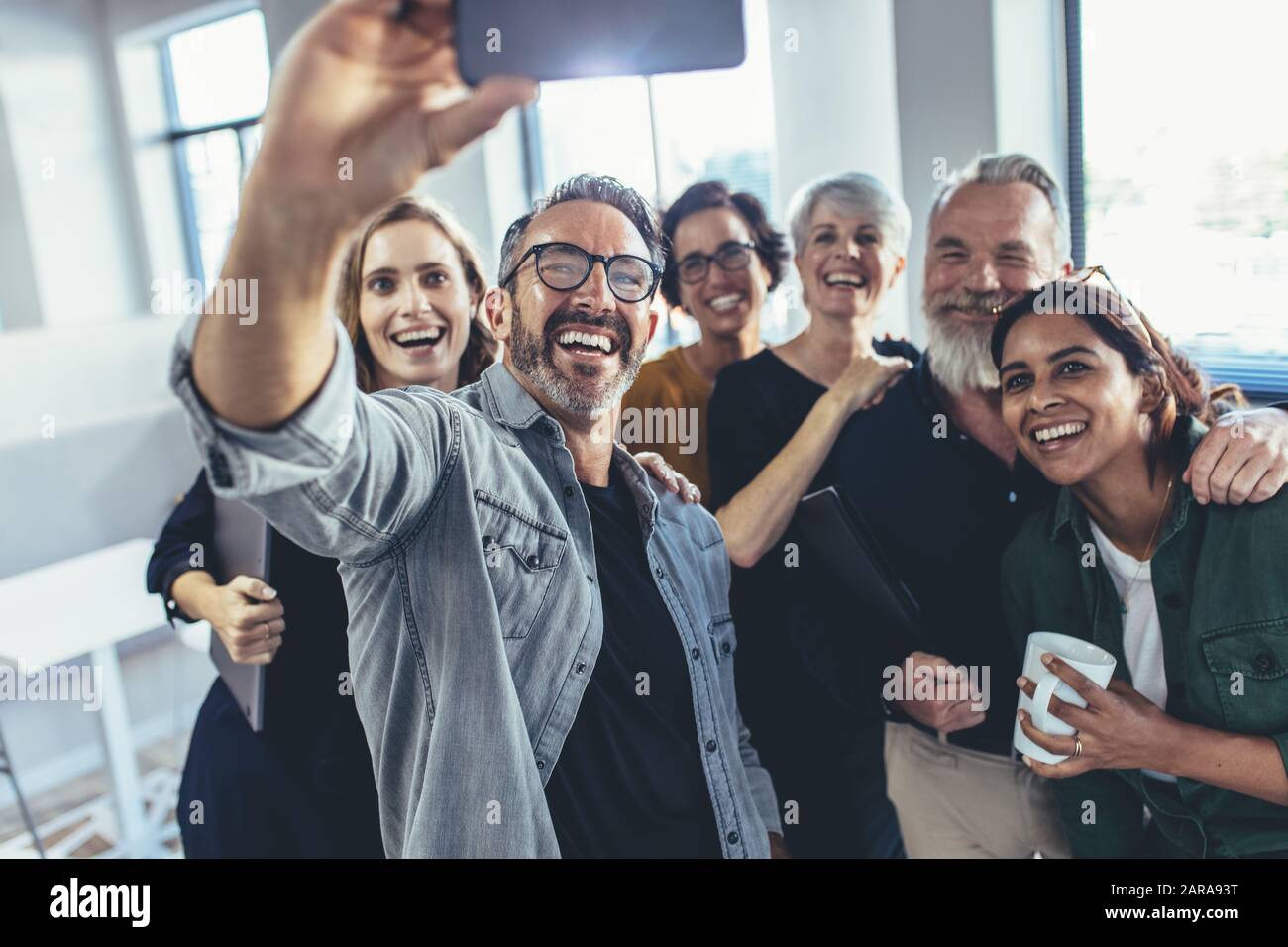 Les gens d'affaires en tenant avec selfies téléphone et souriant. L'équipe commerciale réussie en tenant ensemble selfies dans Office. Banque D'Images