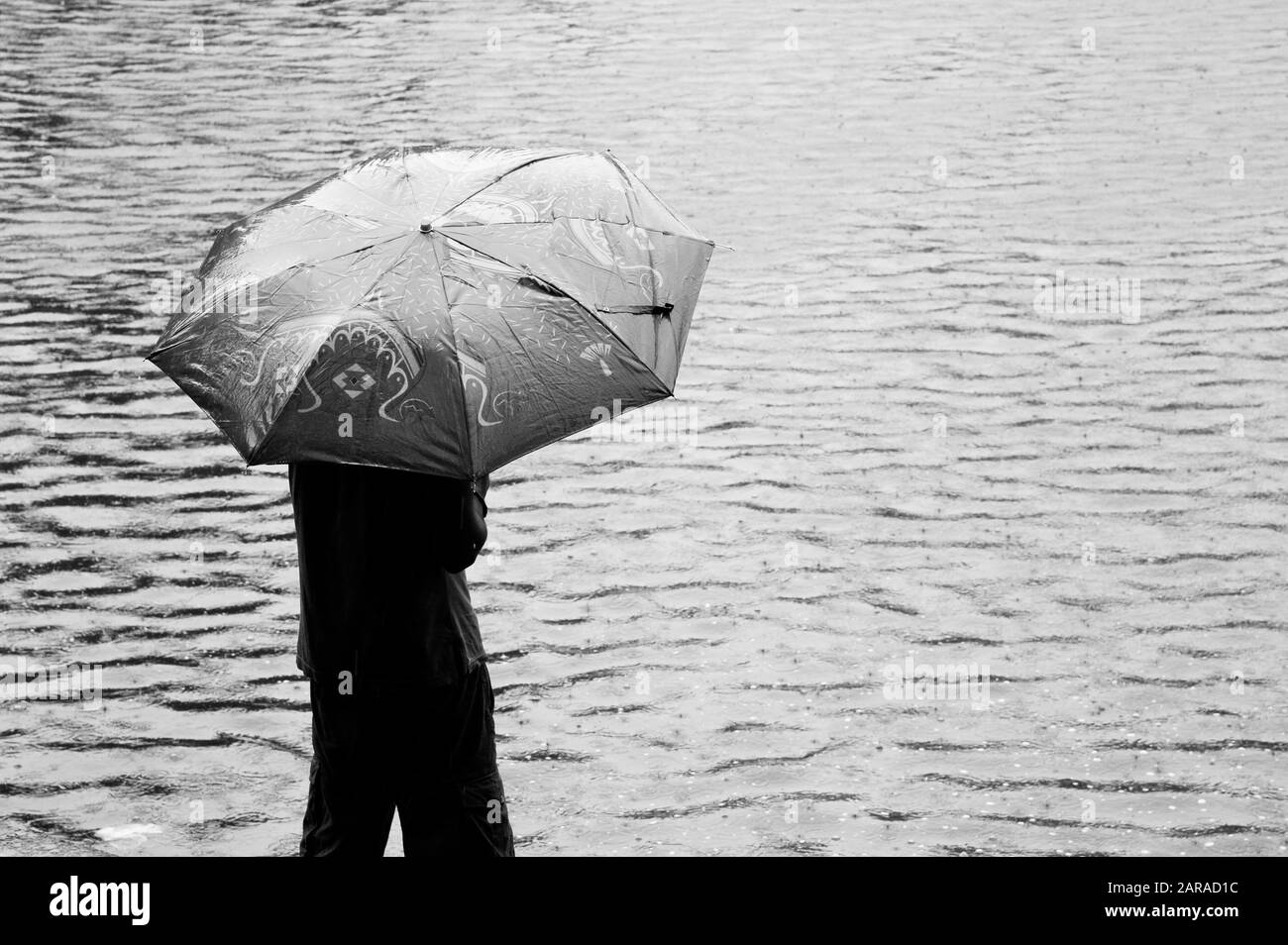 Homme sous parapluie, réservoir d'eau Banganga, Walkeshwar, Malabar Hill, Mumbai, Maharashtra, Inde, Asie Banque D'Images