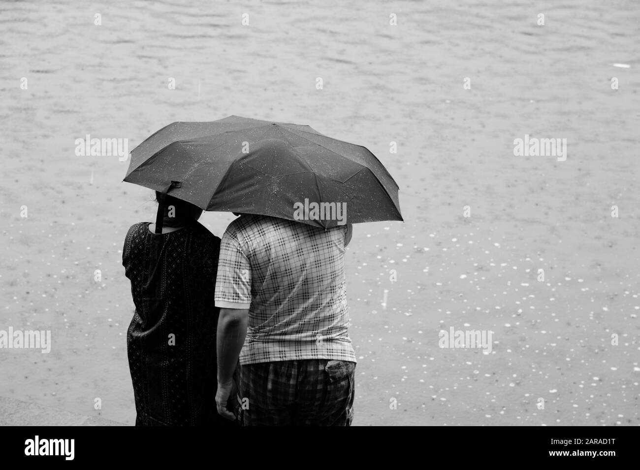 Couple sous parapluie, réservoir d'eau Banganga, Walkeshwar, Malabar Hill, Mumbai, Maharashtra, Inde, Asie Banque D'Images