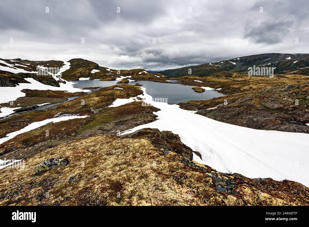 Paysage norvégien typique avec les montagnes enneigées et le lac clair près de la célèbre Aurlandsvegen (Bjorgavegen), mountain road, Aurland, Norvège. Banque D'Images