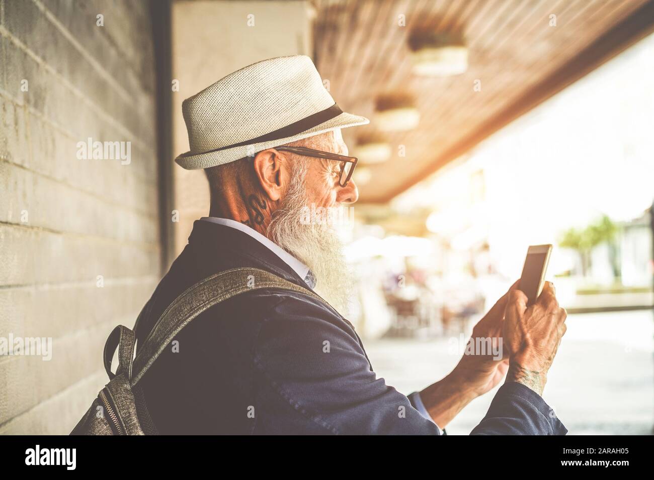 Homme senior branché utilisant l'application smartphone dans le centre-ville en plein air - voyageur de mode mûr s'amuser avec les nouvelles technologies de tendances - Tech et joyeuse el Banque D'Images