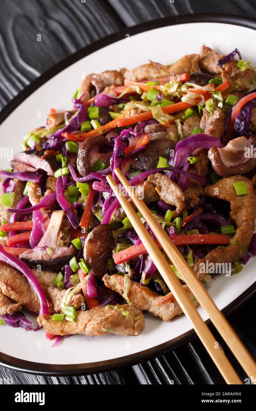 Porc chinois chaud moo shu avec légumes gros plan dans une plaque sur la table. Vertical Banque D'Images