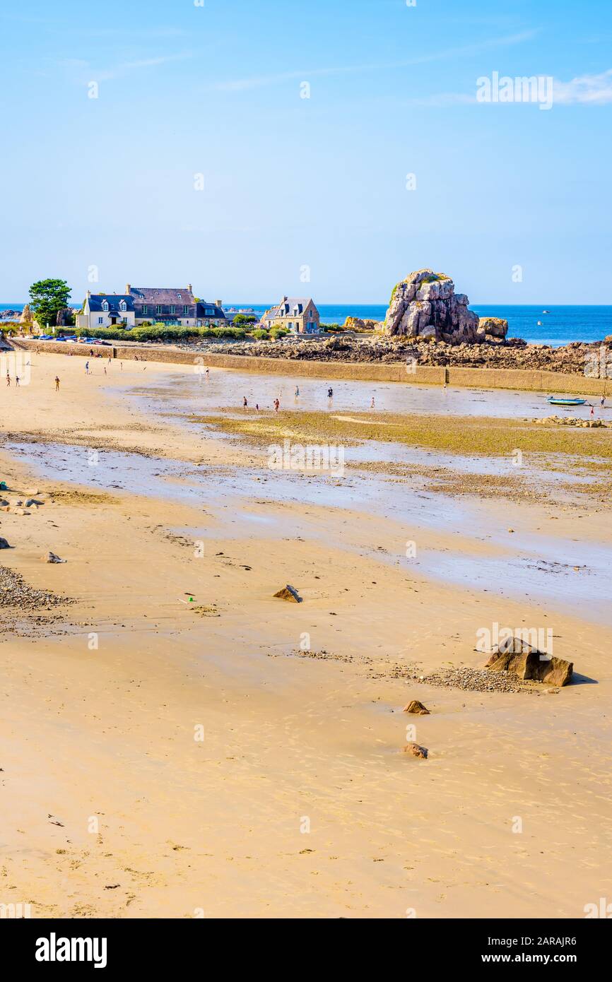 La plage de sable et le petit port de Pors Hir à marée basse dans la municipalité de Plougrescant dans le nord de la Bretagne, France, par une journée d'été ensoleillée. Banque D'Images