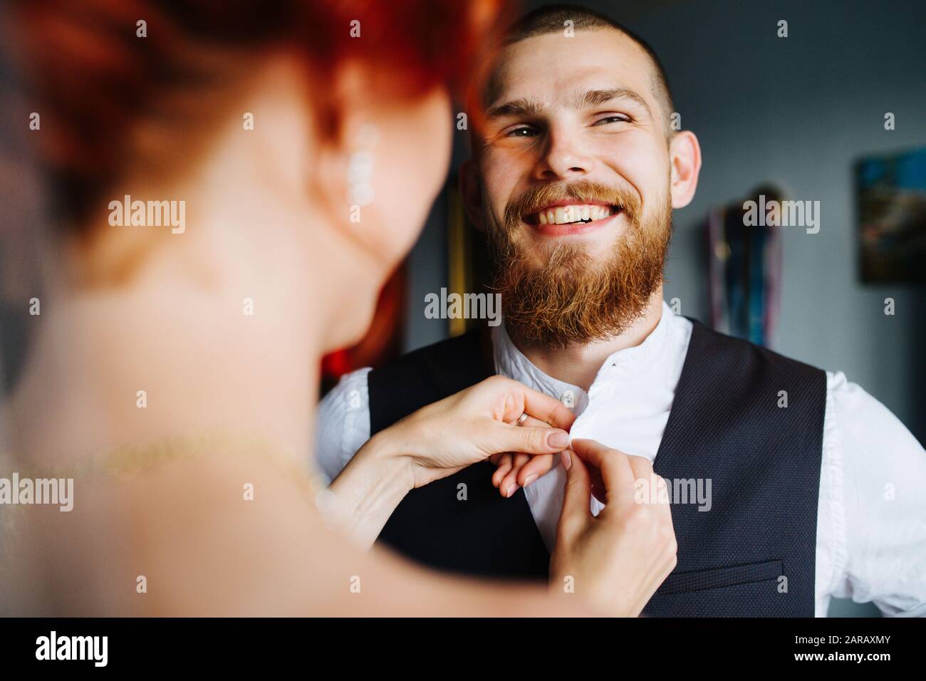La chemise de boutonage de la mariée de son futur mari avant la cérémonie du mariage Banque D'Images