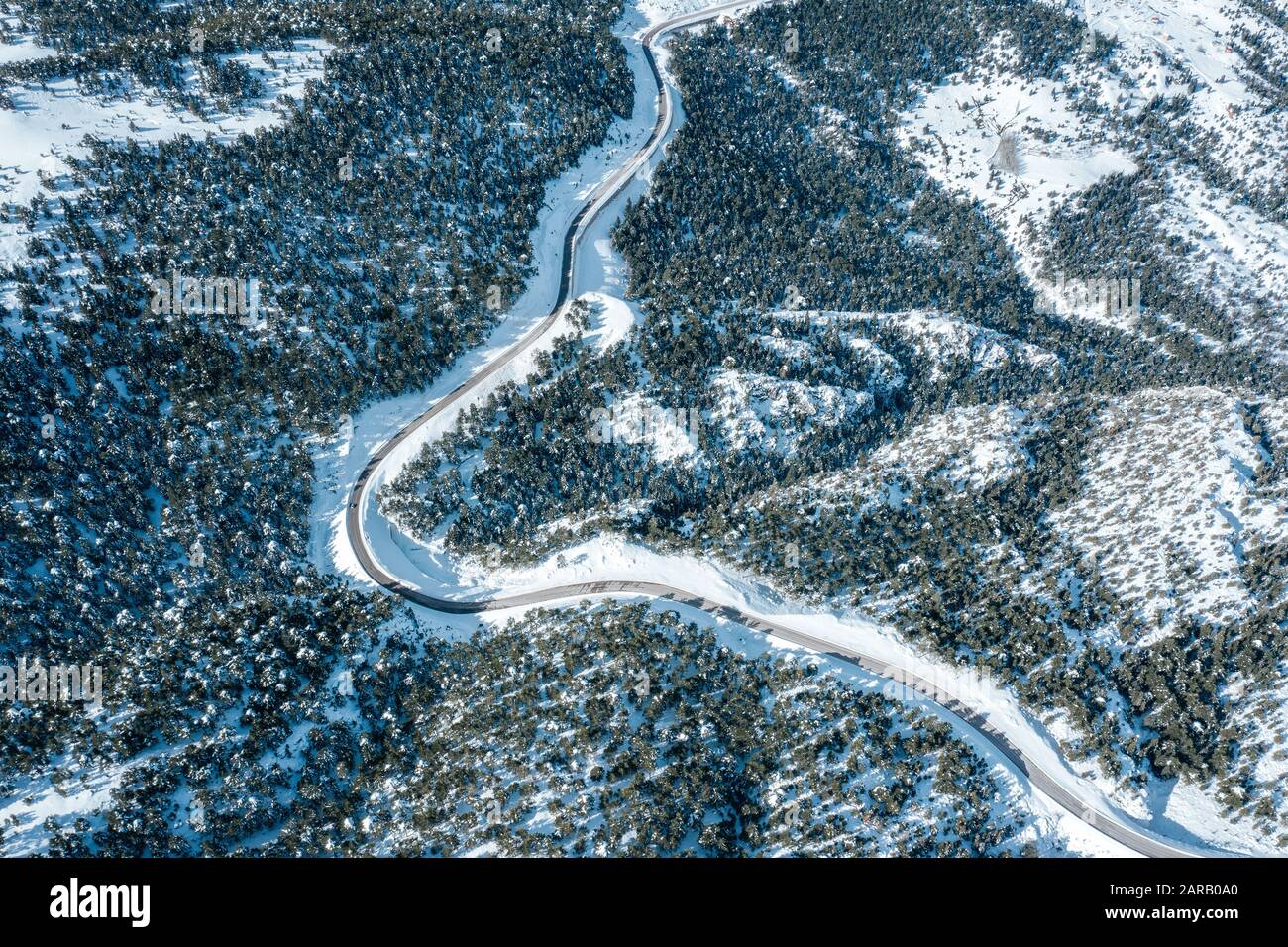 Vue aérienne d'une autoroute dans la forêt et les montagnes avec neige couverte Banque D'Images