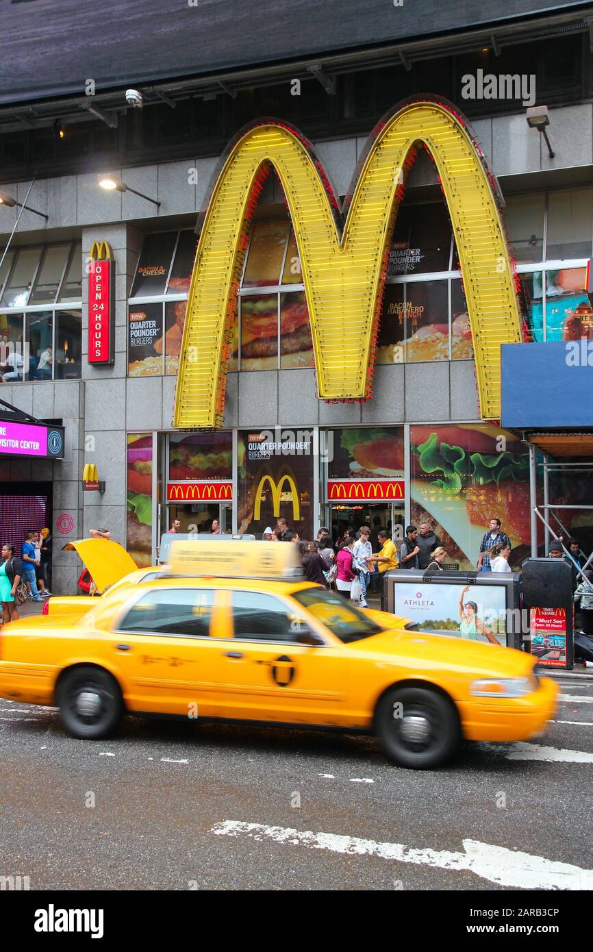 New YORK, États-Unis - 10 JUIN 2013 : un taxi jaune conduit le long Du restaurant Fast-food Times Square McDonald à New York. Banque D'Images