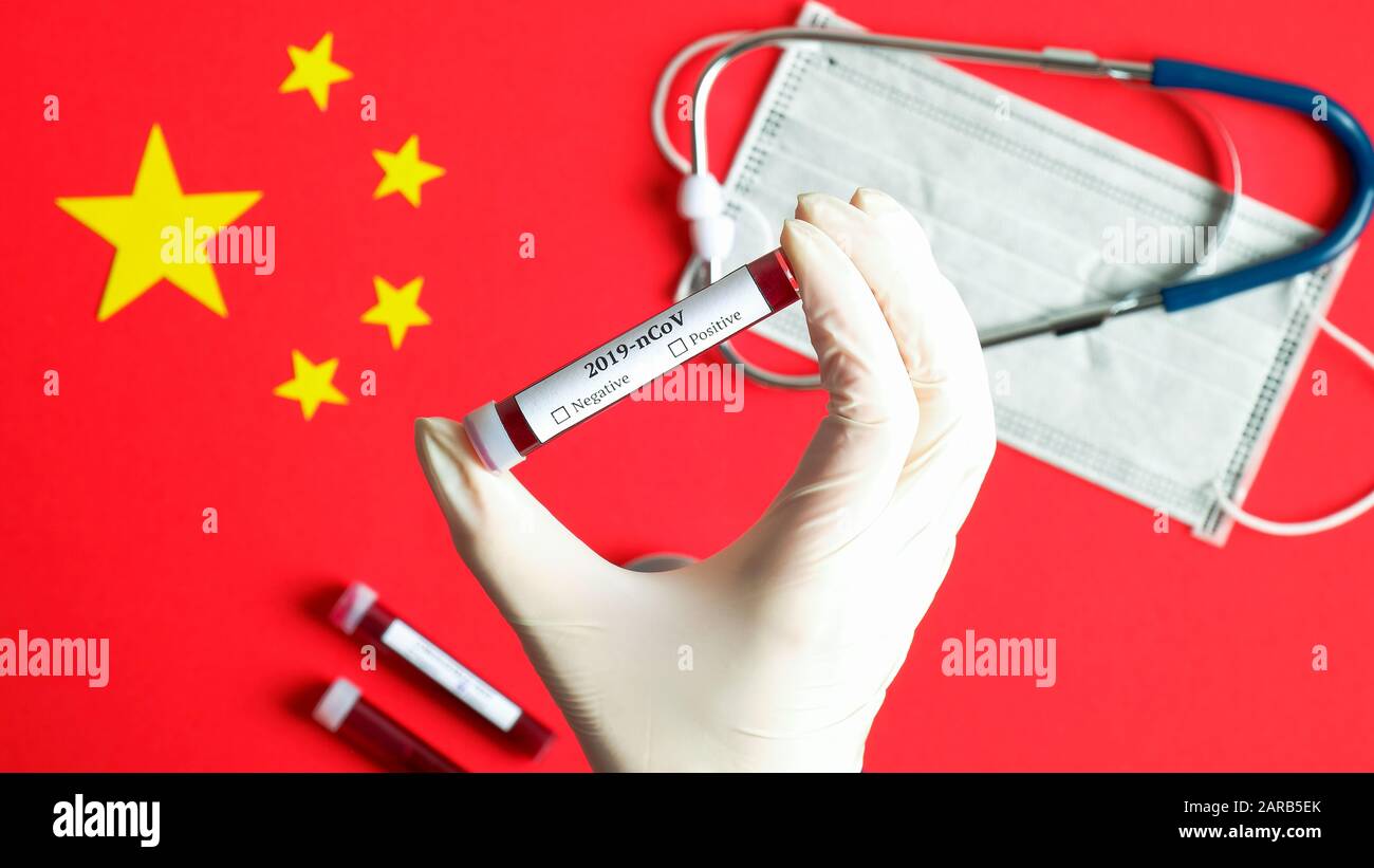 Nouveau concept de coronavirus 2019-nCoV. Main d'infirmière tenant le tube de test sanguin sur le drapeau chinois avec masque respiratoire et stéthoscope. Le coronavirus de Wuhan surpasse Banque D'Images