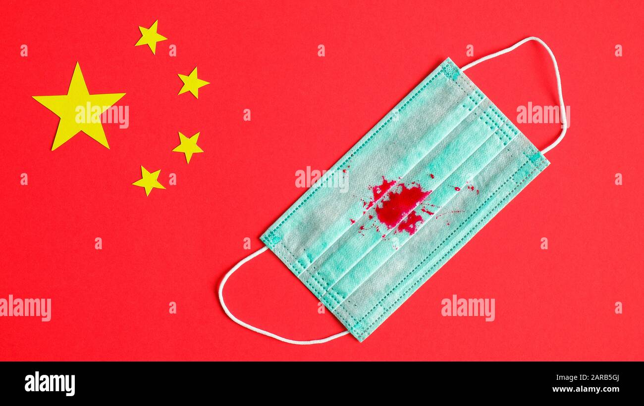 Nouveau concept de coronavirus 2019-nCoV. Masque de protection respiratoire avec tache de sang de pneumonie toussez sur le drapeau chinois. Éclosion de coronavirus de Wuhan, in Banque D'Images