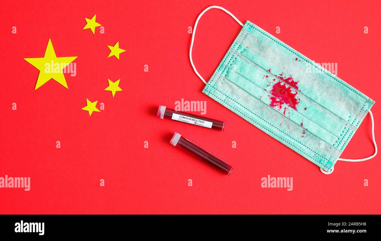 Nouveau concept de coronavirus 2019-nCoV. Masque de protection respiratoire avec tache de sang de pneumonie toux et tubes de test sanguin sur le drapeau de la Chine. Wuhan coro Banque D'Images