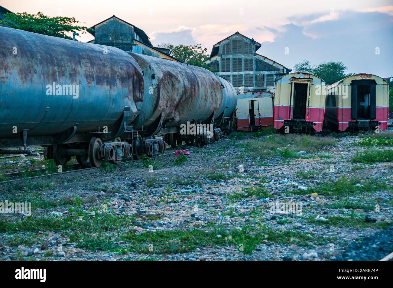 Anciens wagons et voitures devant les hangars à moteur de l'ère coloniale française qui abritent encore un certain nombre de vieilles locomotives à vapeur, Phnom Penh, Cambodge Banque D'Images