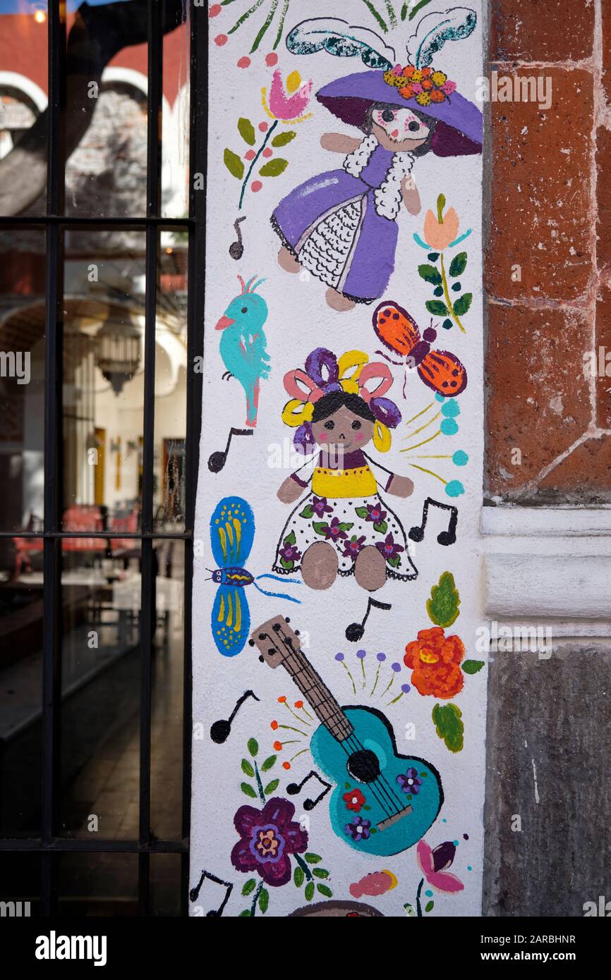 Gros plan sur un cadre de porte peint à la main, avec divers motifs inspirés de la musique dans la vieille ville coloniale. Puebla, Mexique Banque D'Images