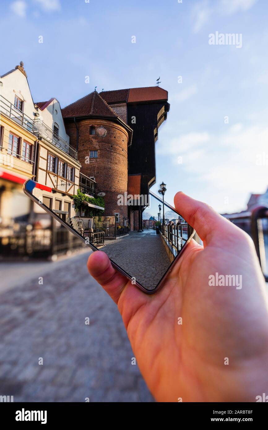 Effet tridimensionnel : l'ancienne grue dépasse du smartphone, concept de guide touristique. Banque D'Images