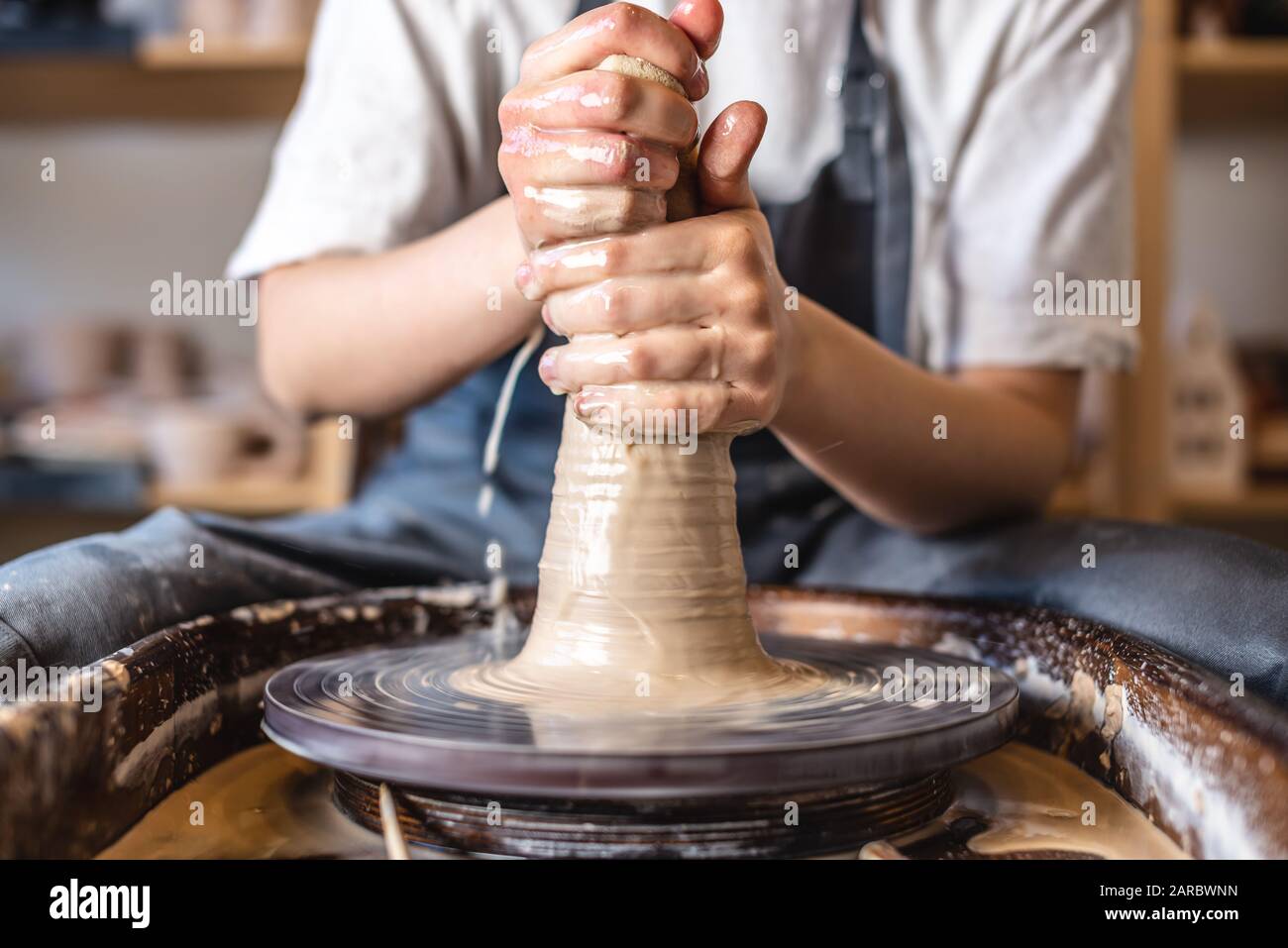 le potier enseigne le artisanat à le enfant. fermer de une potier mains et  une enfant main avec une produit sur une potier roue. travail avec argile.  argile Maître classe. 21683915 Photo