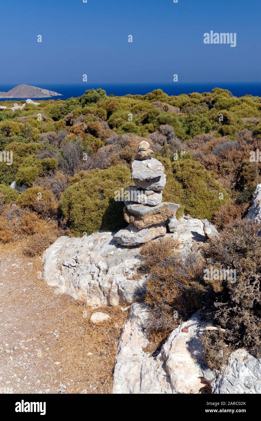 Pile de pierres marqueur de chemin de pied, ces avec la peinture rouge sur les rochers sont une caractéristique des sentiers sur Tilos, îles Dodécanèse, sud de la mer Égée, Grèce. Banque D'Images