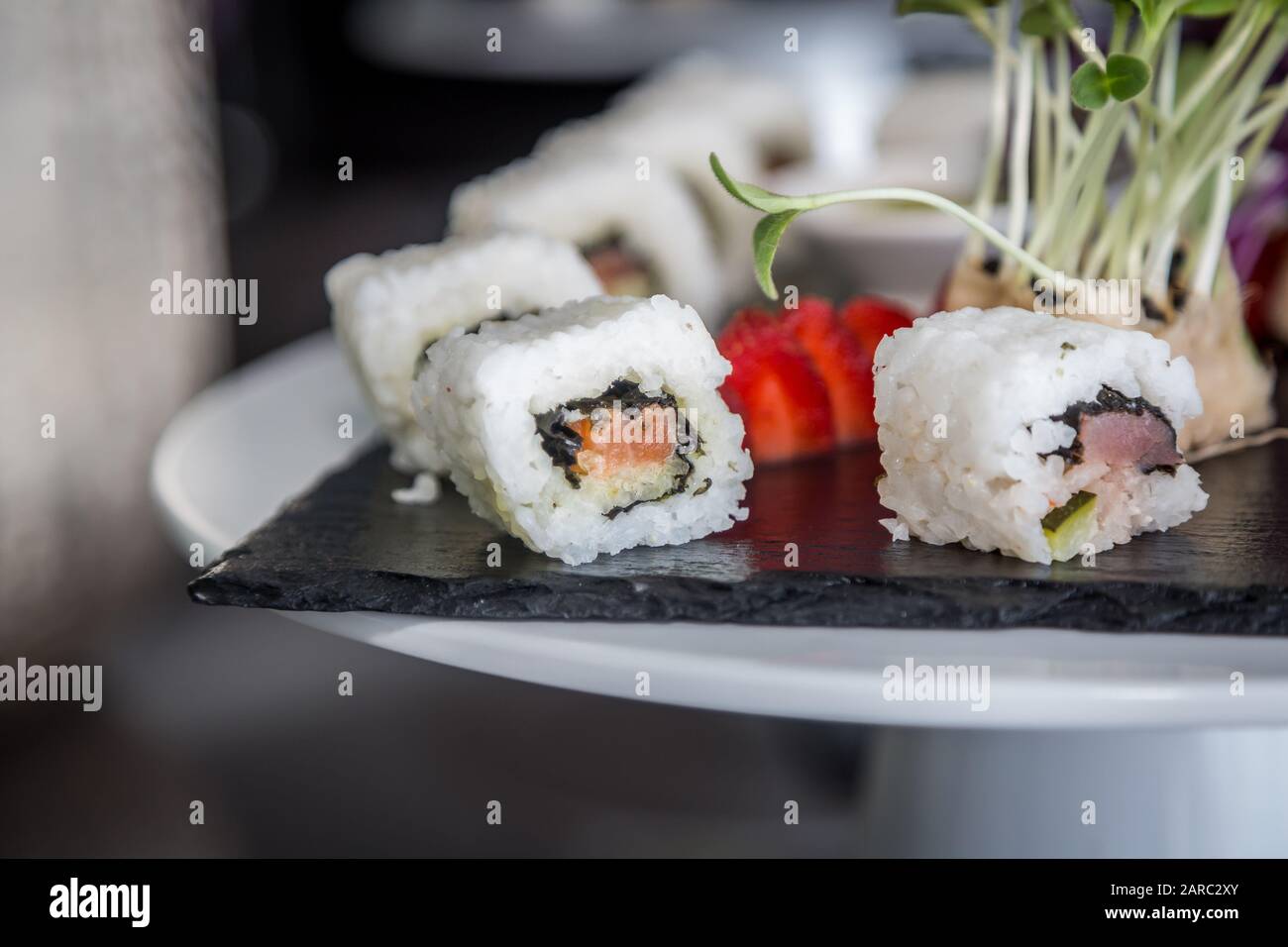 Rouleau à sushi cuisine japonaise sur plaque noire. Jeu de rouleaux à sushi avec saumon, riz au caviar et légumes. Menu du restaurant japonais. Banque D'Images