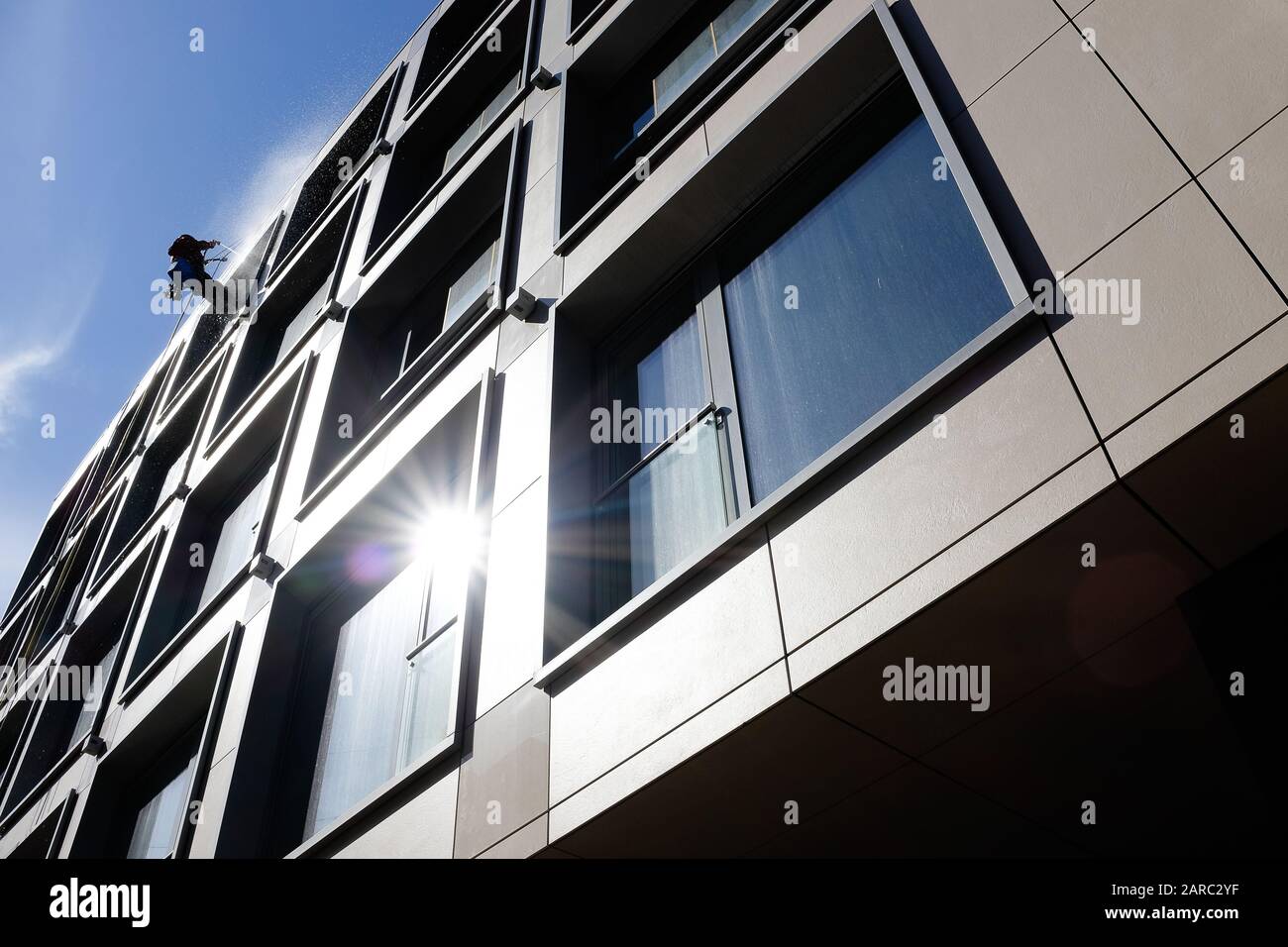 Un nettoyant pour vitres courageux descend dans un bloc de bureaux Banque D'Images