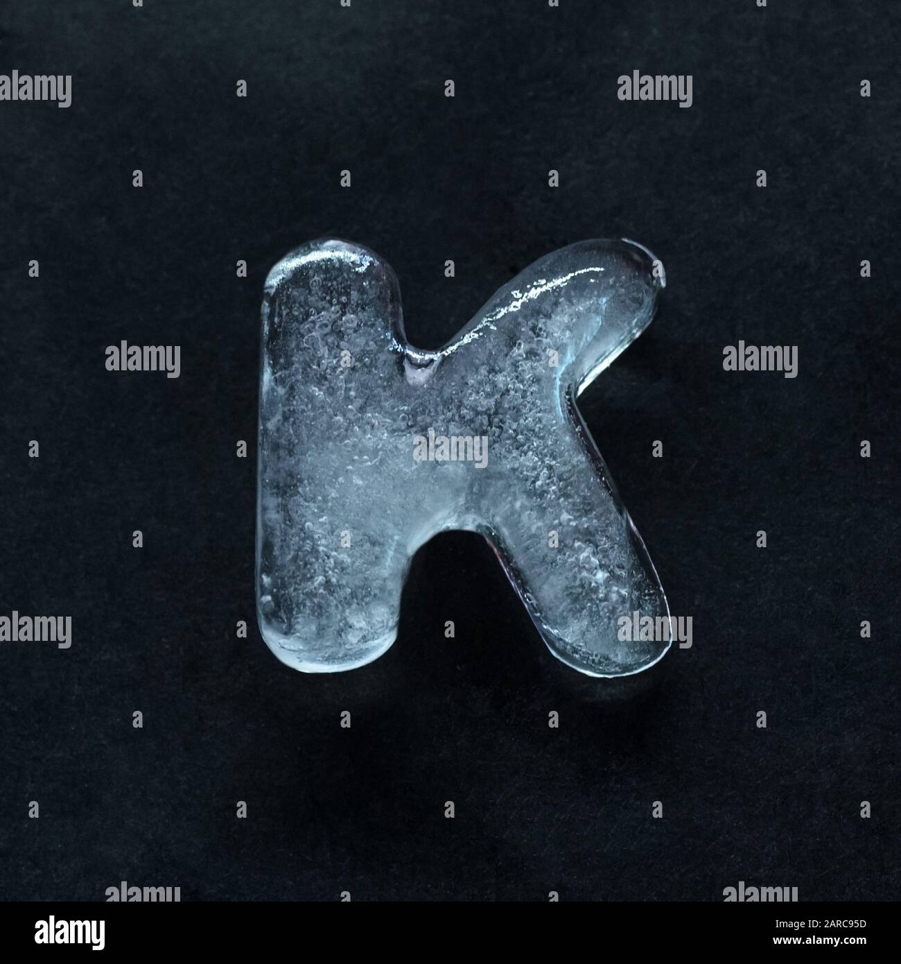 Fusion du discours. Lettres brillantes et bien structurées de l'alphabet faites à partir de glace isolée sur fond sombre de studio. Collecter pour combiner en mots. CopySpace pour insérer votre publicité. Banque D'Images