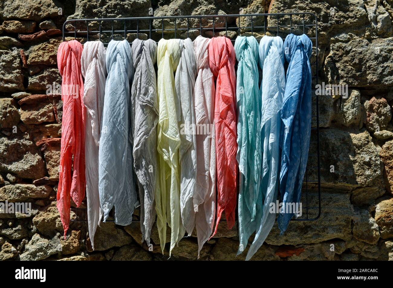 Une collection de tissus suspendus à plusieurs foulards sur un rack Banque D'Images
