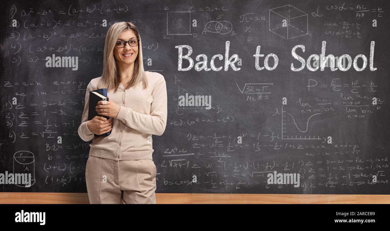 Professeur de femme debout devant un tableau noir avec texte de retour à l'école Banque D'Images