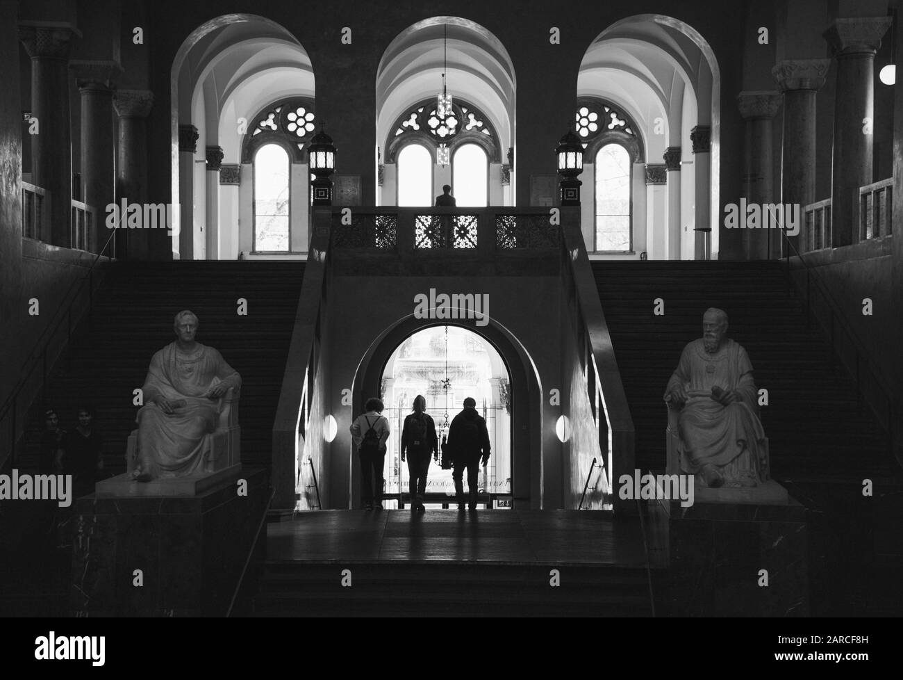 Photo grand angle de trois personnes marchant dans l'arche dans un bâtiment Banque D'Images