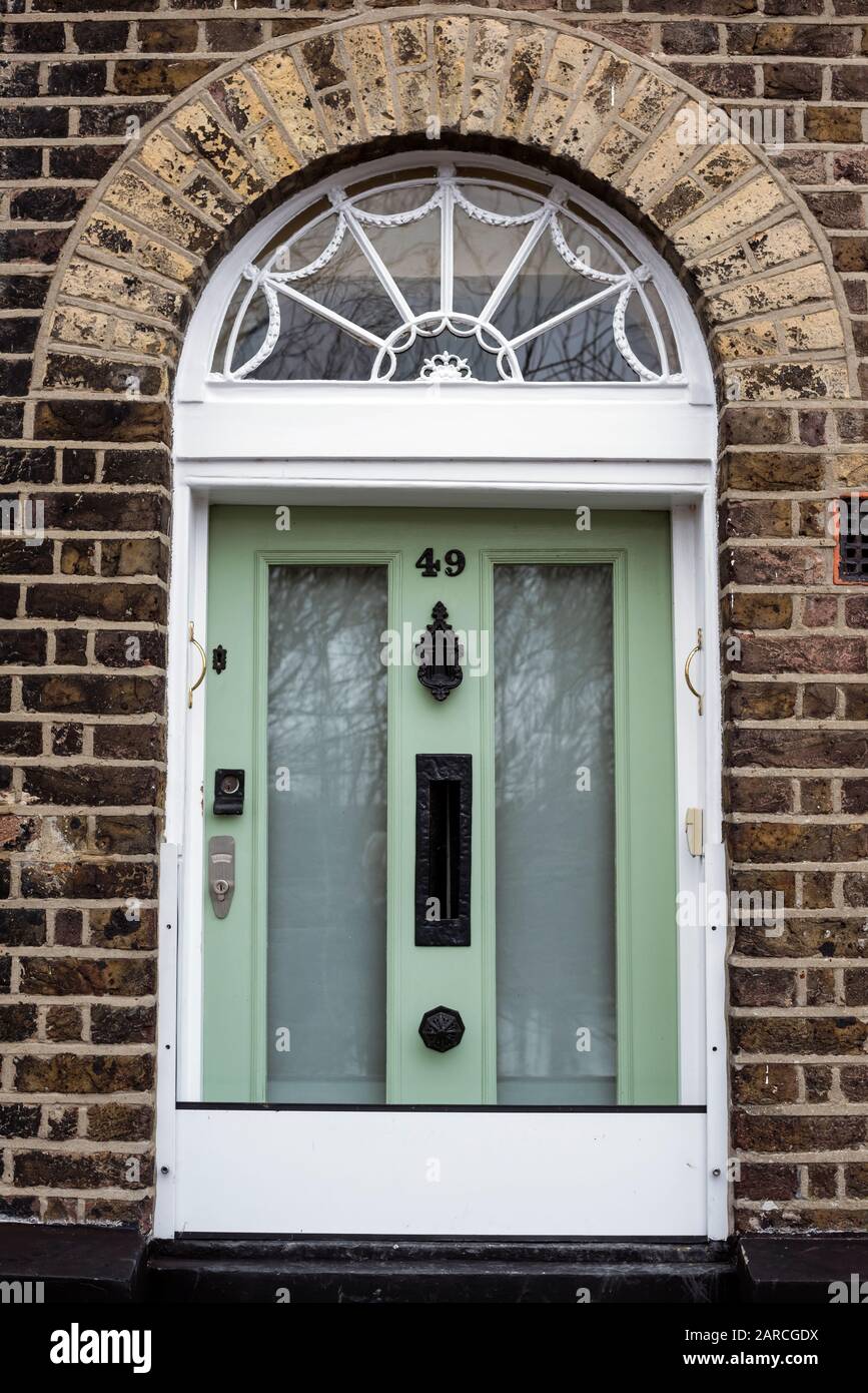 Porte avant inhabituelle de trois quarts de taille à la maison au bord de la rivière avec pas levé, dans le cadre des défenses contre les inondations, à Strand on the Green, Kew, Londres, Royaume-Uni. Banque D'Images