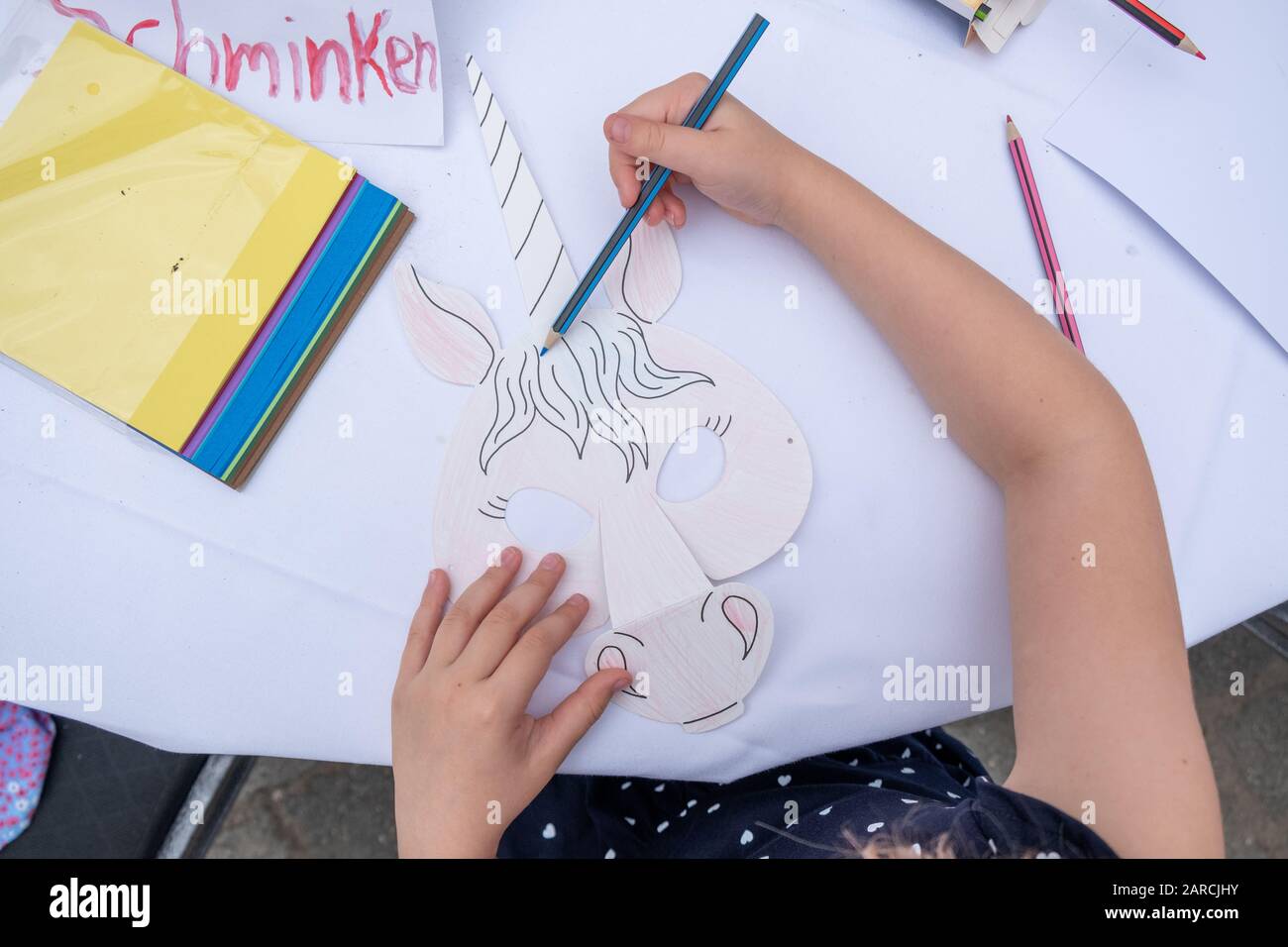 un petit enfant peint une image avec des crayons. Banque D'Images