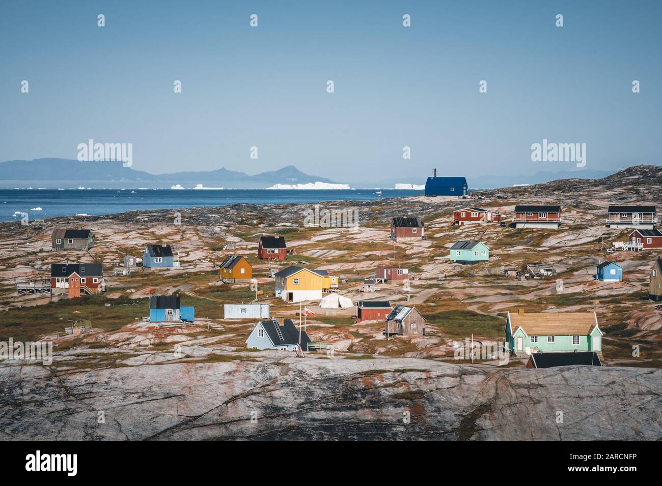 Maison typique de pêcheurs bleu colorée en bois avec iceberg dans la baie de Disko Groenland et Ilulissat. Architecture typique dans le cercle arctique. Été Banque D'Images