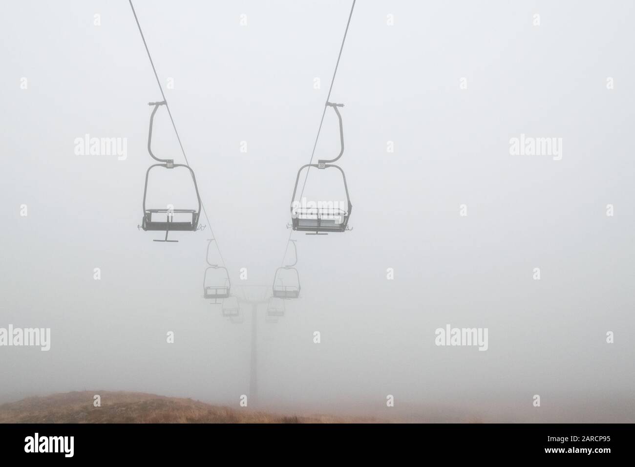 Remontées mécaniques vides dans le brouillard profond du centre de ski Glen Cie, Écosse. Banque D'Images